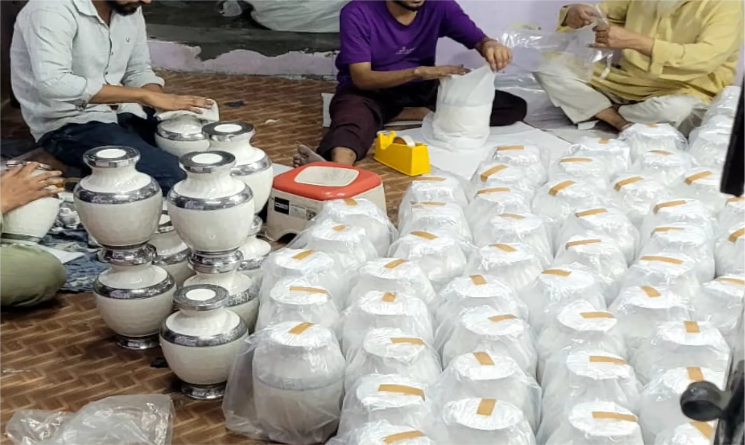 Team finishing and packing white cremation urns