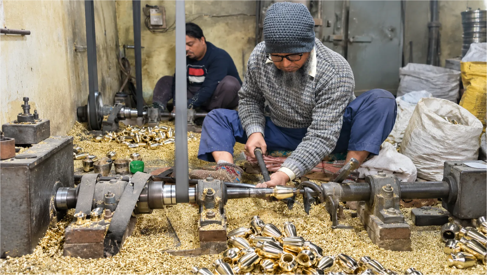 Artisans working at metal lathes in the workshop