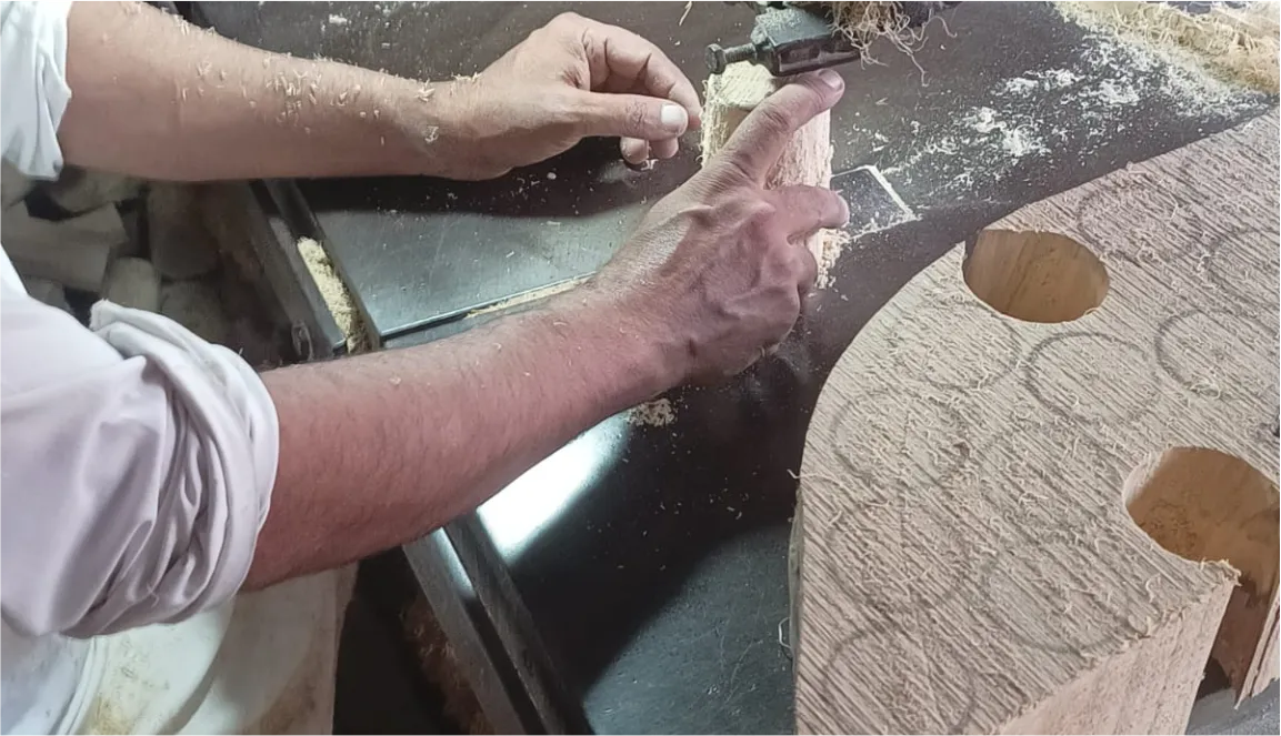 Hands engraving a pattern into a wooden surface